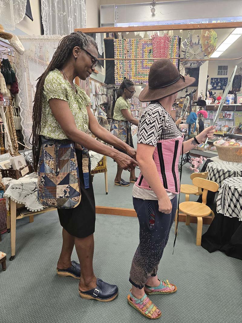 Erin lacing Quinn into a corset