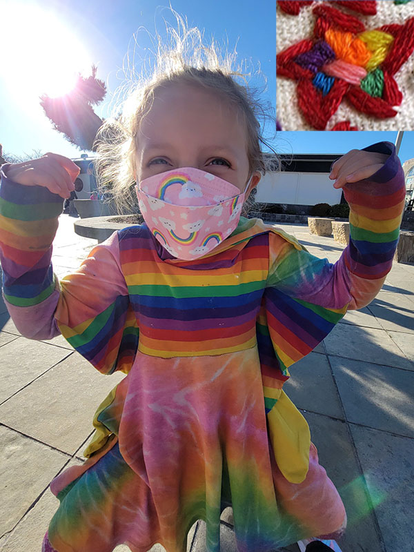 Eliza in a rainbow shark dress and a rainbow star representing this
