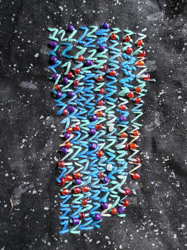 Rows of Z's in different shades of blue, many with a red or purple bead on them.